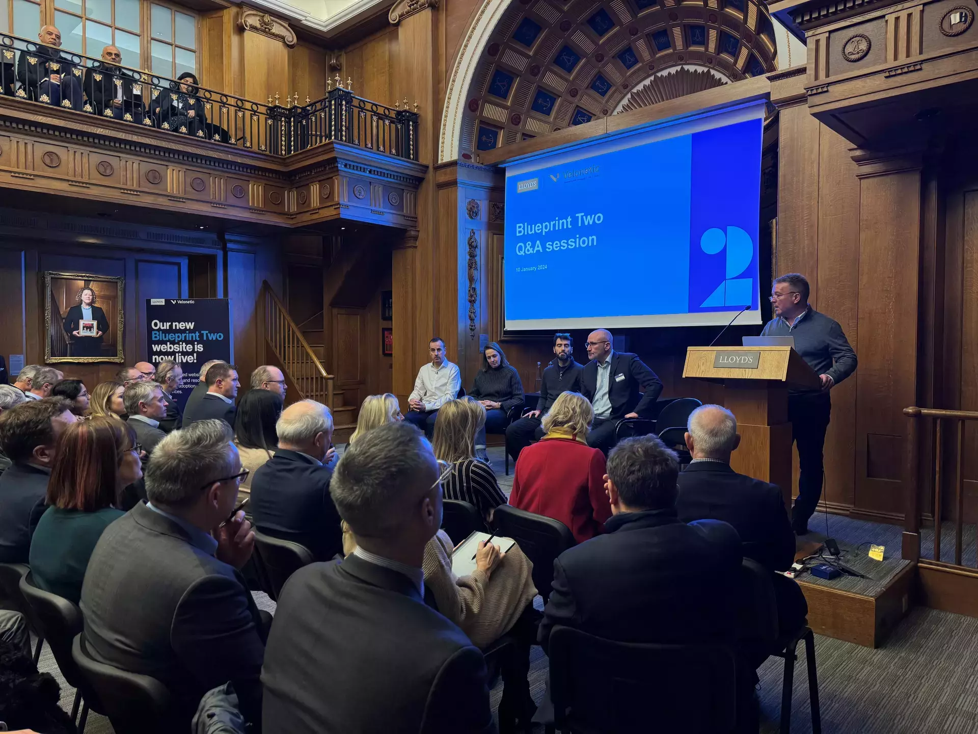 Image of crowd and speakers at 10 January Q&A session